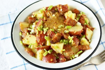 German potato salad with fried bacon and mustard dressing. traditional for oktoberfest festival.