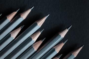 Gray sharpened pencils isolated on black background.