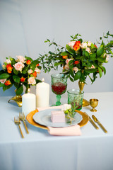 turquoise-colored table with gold plates and cutlery
