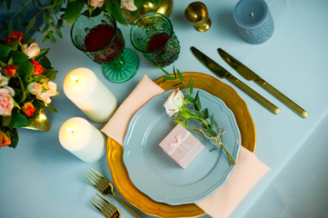 turquoise-colored table with gold plates and cutlery