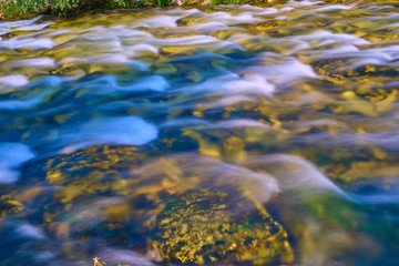 Mountain cold fresh water turquoise color of the Alpine mountains. Photo taken at long exposure.