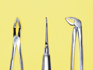 Dental surgical instrument on yellow background with copy space. Dental care concept