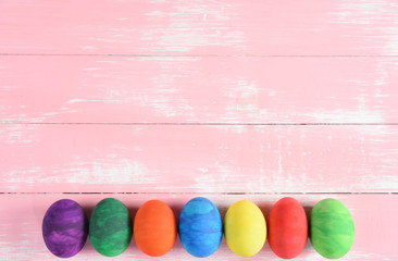 Colorful handmade easter eggs on pastel pink wooden background. Happy Easter Day, Easter eggs concept.