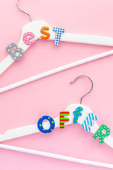 White hangers with sale text on pink background