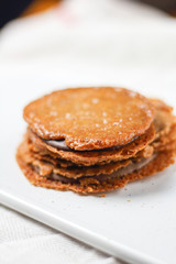 chocolate filled almond brown cookies sandwiches biscuits on white plate. Homemade delicious dessert