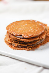 Fototapeta na wymiar chocolate filled almond brown cookies sandwiches biscuits on white plate. Homemade delicious dessert
