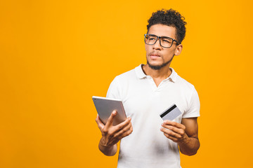 Afro american black man shopping online using tablet pc and making payment with credit card.