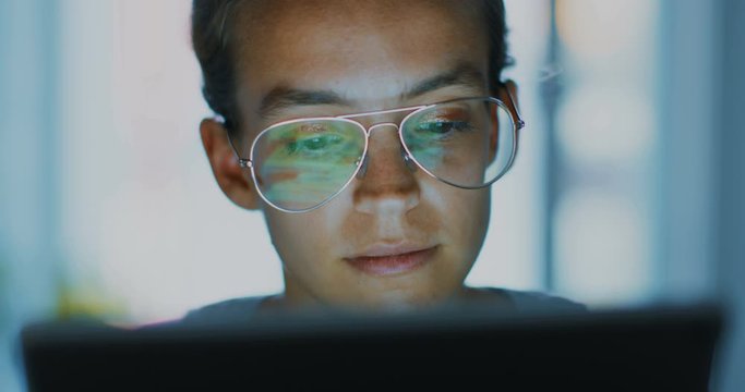 High quality 4k 12bit footage of Beautiful girl using Tablet PC sitting on couch at home. Woman surfing web, social networks, looking something in online shop. Cinematic look