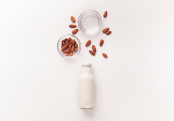 Vegan milk of almonds in glass bottle on white background