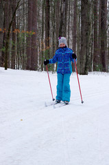 Girl cross-country skiing in woods