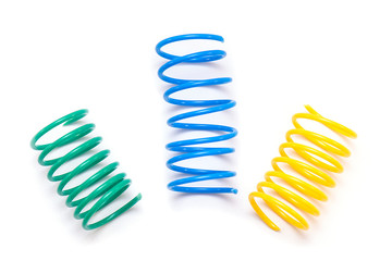 Yellow, Green and Blue plastic Spring Toy or Spirals isolated on white Background