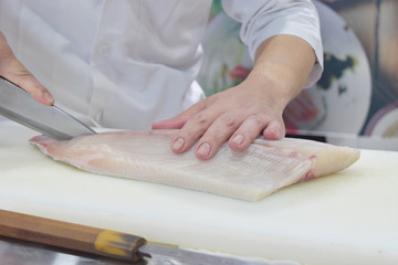 Obraz na płótnie Canvas Chef preparing by use knife slicing raw fish fresh on cutting board.