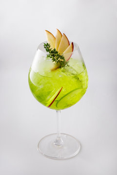 Apple Cocktail In a luxuriously shaped glass consisting of ice and sliced apples, decorated with green herbs Filmed on a white scene