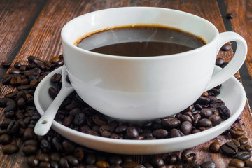 Coffee cup and coffee bean on the wooden table