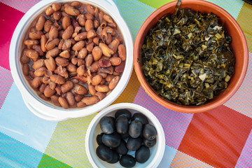 Top view of Portuguese traditional snacks. Baked beans, Sauteed cabbage and black olives