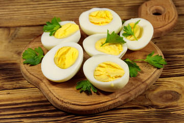 Boiled eggs with parsley on cutting board on a wooden table
