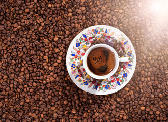 Turkish coffee in a traditional cup on coffee beans