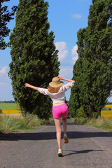 Happy young girl running outdoors, vertical back view. People, travel , happiness concept.