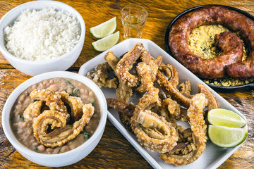 Typical food table in the interior of Brazil. Pork, beans, bean tutu, pork rinds, rice and farofa. Gastronomic tursimo concept, photo for restaurant menu.
