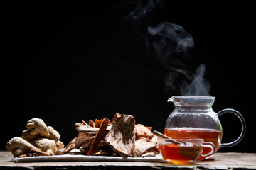 Ginger juice and herbal water  one glass of healthy roots and one hot ginger and smoke  and a black background herbal root - Healthy herbal water concept -