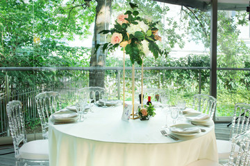 Beautiful composition with flowers on the tables and candles for guests at a wedding or a birthday party