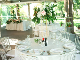 Beautiful composition with flowers on the tables and candles for guests at a wedding or a birthday party