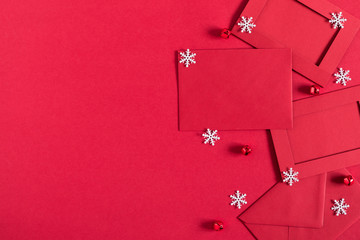 Christmas trendy composition. Xmas decorations, envelope, postcard on red background. Christmas, New Year, winter concept. Flat lay, top view, copy space