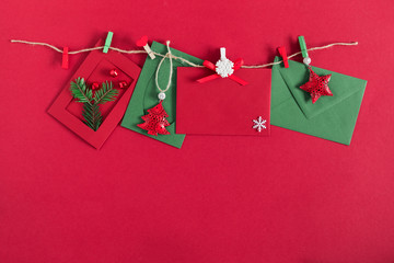 Christmas trendy composition. Xmas decorations, envelope, postcard on red background. Christmas, New Year, winter concept. Flat lay, top view, copy space