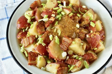 German potato salad with fried bacon and mustard dressing. traditional for oktoberfest festival.