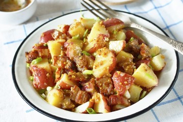 German potato salad with fried bacon and mustard dressing. traditional for oktoberfest festival.