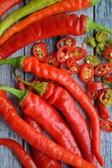Close-up of sliced chili peppers on an old wooden surface, selective focus.