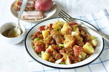 German potato salad with fried bacon and mustard dressing. traditional for oktoberfest festival.