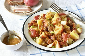 German potato salad with fried bacon and mustard dressing. traditional for oktoberfest festival.