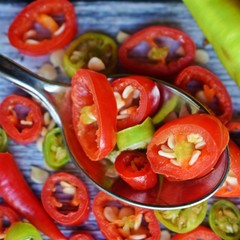 Close-up of sliced chili peppers on an old wooden surface, selective focus.