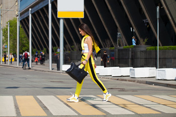 Portrait of a young beautiful brunette woman in yellow tracksuit