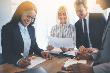 Smiling group of diverse businesspeople working around an office