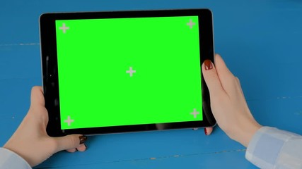 Mock up, entertainment, copyspace, template, leisure time, chroma key, green screen, technology concept - woman sitting and looking at black digital tablet computer device with blank green display