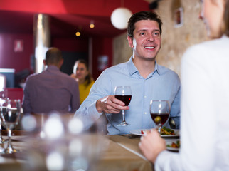 Smiling man with girlfriend on friendly meeting over dinner