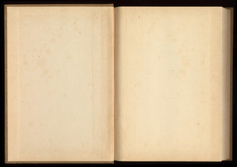 Old open book with blank pages on black background.