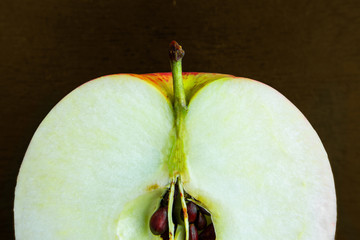 Sliced apple macro image on dark background. Close up of fresh ripe fruit with core and kernels