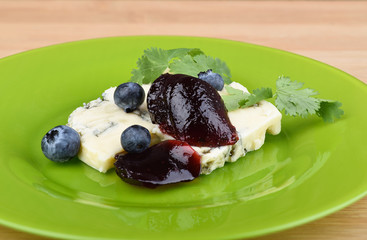 Blue cheese breakfast with blueberry jam and cilantro.