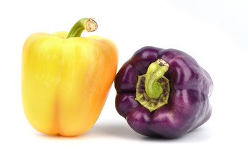 Purple and orange fresh sweet peppers isolated on white background.
