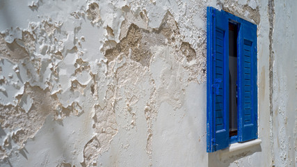 eine weiße Wand mit einem blauem Fenster