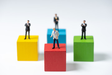 business miniature people standing on stack of wood cube building block