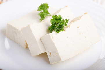 Soy Bean curd tofu on clay dish closeup. Non-dairy alternative substitute for cheese