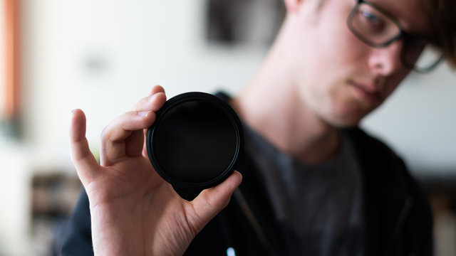 photography influencer holding a camera filter