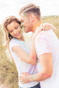 attractive woman and handsome man smiling and kissing outside