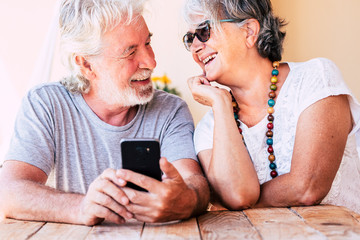 Couple of old happy cheerful people caucasian senior man and woman smiling together each other with love - concept of forever together life - joyful for aged family