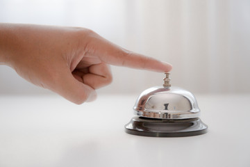hand holding a bell on the table