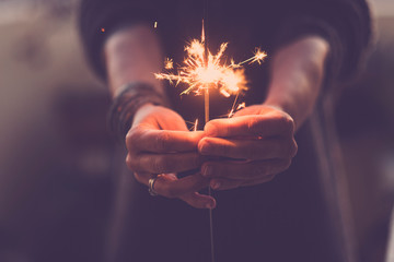Concept of party nightlife and new year eve 2020 - close up of people hands with red fire sparklers...